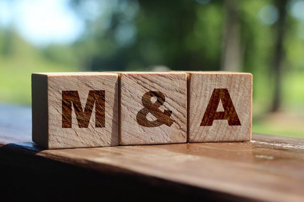 Wooden cubes with the abbreviation M and A on them. Business merges and aquisitions concept.